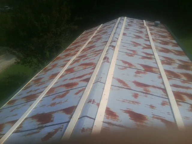 Rusted metal roof panels with new wood purlins before replacement — Storm Damage Roof Repair in Fullerton by Roofing Brothers