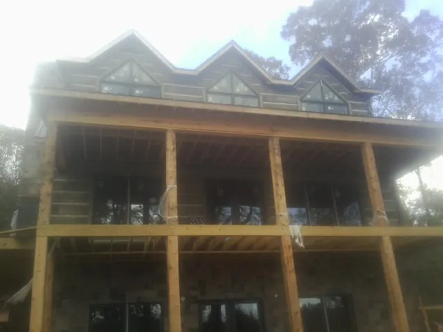 Dormers and porch framing on a large log home under construction — Roof Coating work by our crew in Fullerton